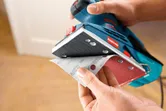 オービタルサンダーにサンドペーパーを取り付ける人。