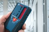 建設中の建物の中でレーザー受信機を持っている人。