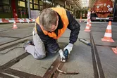 安全装置を装着した人がマルチカッターを使用してコンクリートジョイントから材料を除去します。.