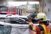 安全装備を身に着けた人が電動工具を使用して損傷した車両を切り開きます。