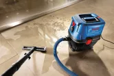 タイル張りの床から水を吸い取る乾湿両用抽出機。