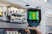 サーモカメラを使用して電気パネルの熱異常を検査しています。