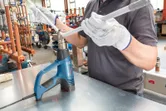 安全装置を装着した人が電気ヒートガンでプラスチックパイプを加熱します。
