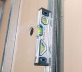 金属スタッドと乾式壁パネルの垂直位置合わせを測定する水準器。