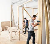 木製の壁を建てる2人の男性。