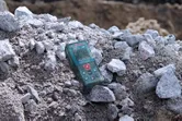 建設現場の岩の山の上に置かれたレーザー測定器。