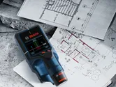建築設計図の上に設置された電子式壁面検出器。