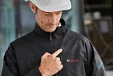 安全装備を着用した人が胸部のボタンを押して加熱ジャケットを起動します。