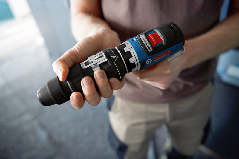 屋内で電動工具用の FlexiClick アダプターを持っている人。