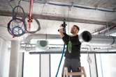 安全装置を装着した人が、天井で FlexiClick アダプター付きのドリルを使用しています。