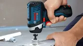 コードレスインパクトドライバーを使用して、金属フレームにボルトを締めます。