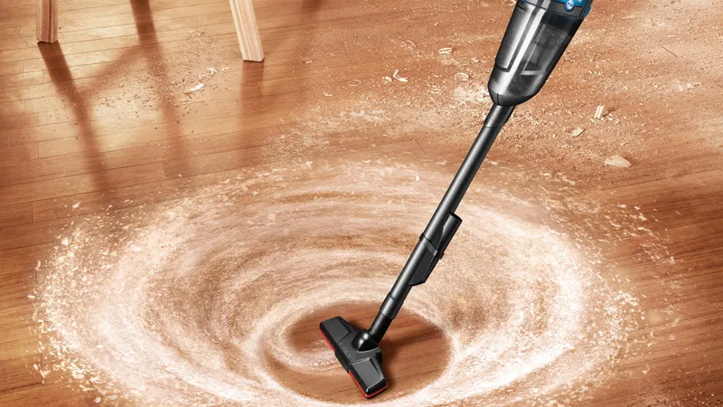 コードレス掃除機は、らせん状に木の床からほこりを素早く除去します。.