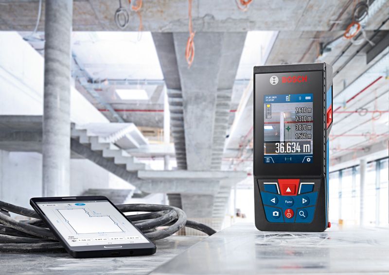 建設現場のコンクリート表面にレーザー測定器とタブレットを設置します。