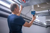 検査カメラを使用して空気ダクトの内部を検査する人。