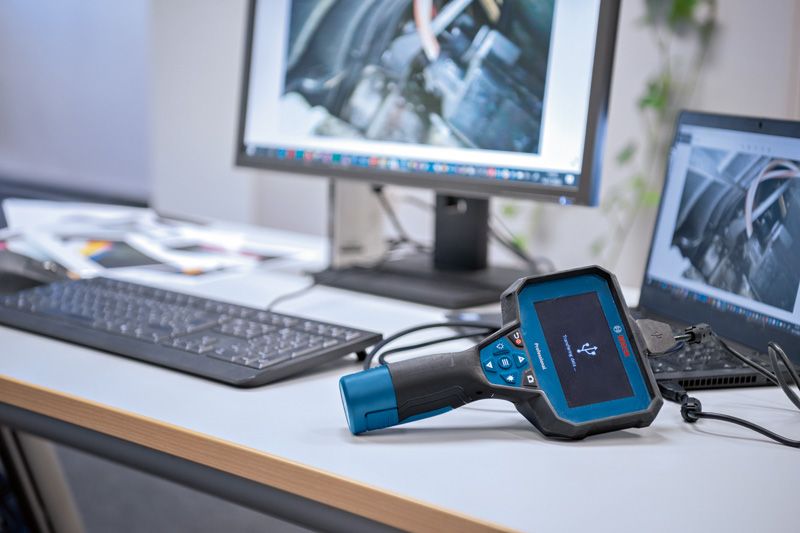 オフィスデスクのコンピューターに接続された検査カメラがエンジンの画像を表示しています。.