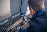 安全装置を装着した人が検査カメラを使用して排水溝を検査しています。