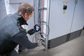安全装備を装着した人が検査カメラを使用して電気配線を検査します。