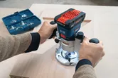 コードレスパームルーターを使用して木材に長方形の溝を彫る人。