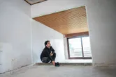 未完成の部屋でレーザーレベルツールを操作する人。.