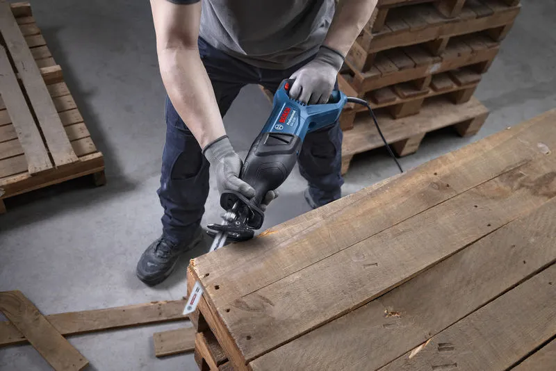 GSA 12-30 安全装置を装着した人がレシプロソーを使用して木製パレットを切断しています。.