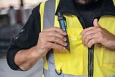 安全装置を着用している人は、非接触型電圧テスターをベストのポケットに入れます。