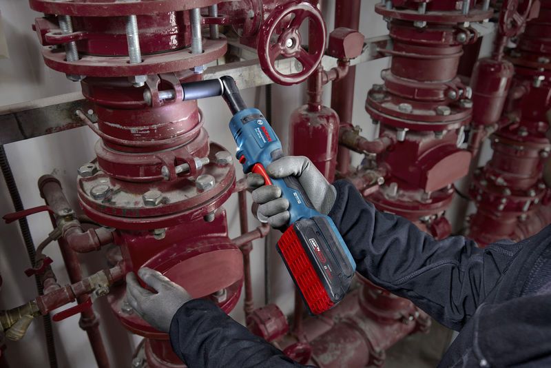 安全装置を装着した人がコードレスラチェットレンチでパイプボルトを締めます。.