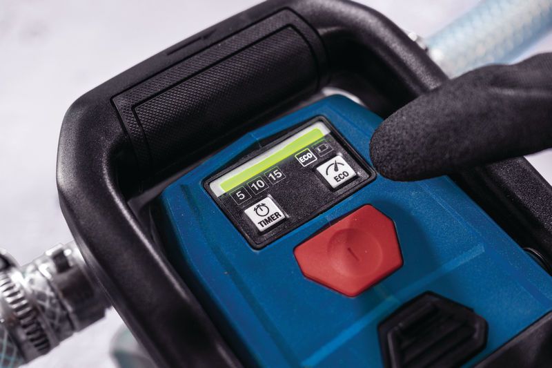 安全装置を装着した人がポータブル電動工具のタイマーボタンを押しています。