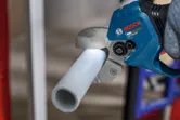 コードレスパイプ剪断機を使用してプラスチックパイプを切断する人。