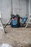 建設現場の床に置かれたコードレスバックパック式集塵機。