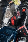 安全装備を身に着けた人が、GPU18V2DI 18V バッテリーを充電ステーションに挿入します。