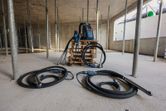 パレット上に 2 つのコンクリート バイブレーターとバックパック電源を備えた建設現場。