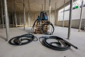 パレット上に 2 つのコンクリート バイブレーターとバックパック電源を備えた建設現場。